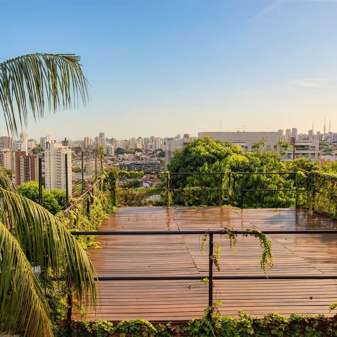 Deck de madeira no topo da EcoCasa, com vista para os prédios de São Paulo